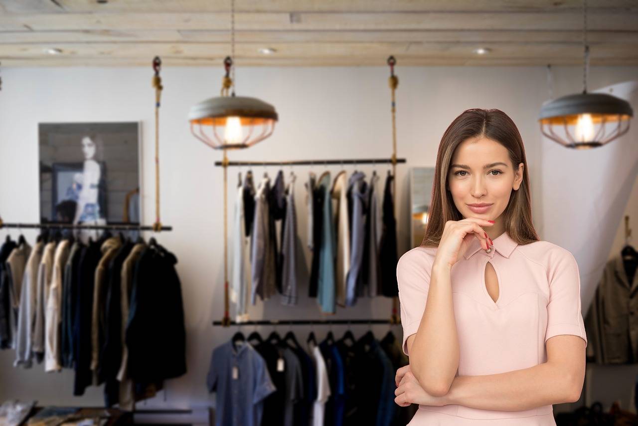 woman smiling at camera inside clothing store