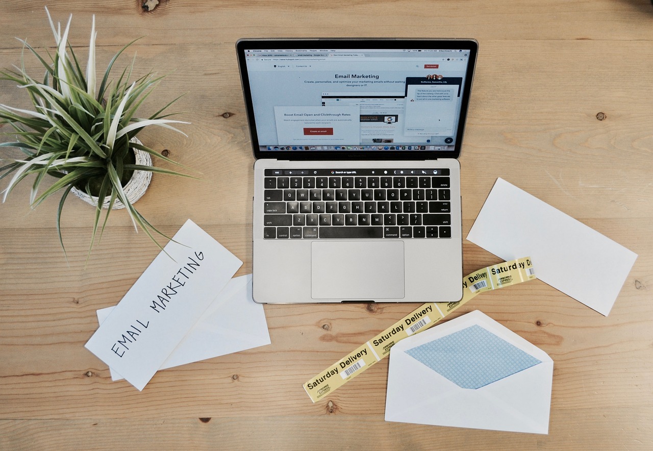 a laptop on a desk with an email marketing platform on the screen.